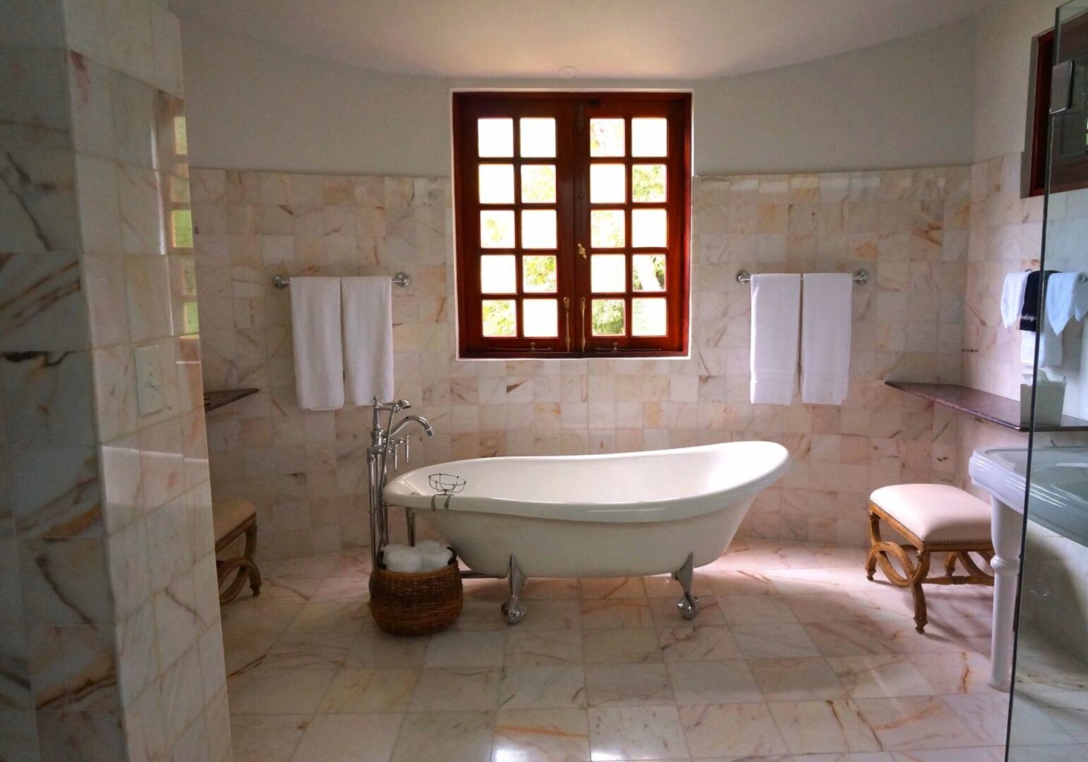 A bathroom with a tub and two windows.